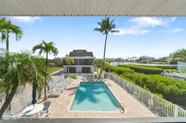 Community pool with a patio, a water view, and a sunroom