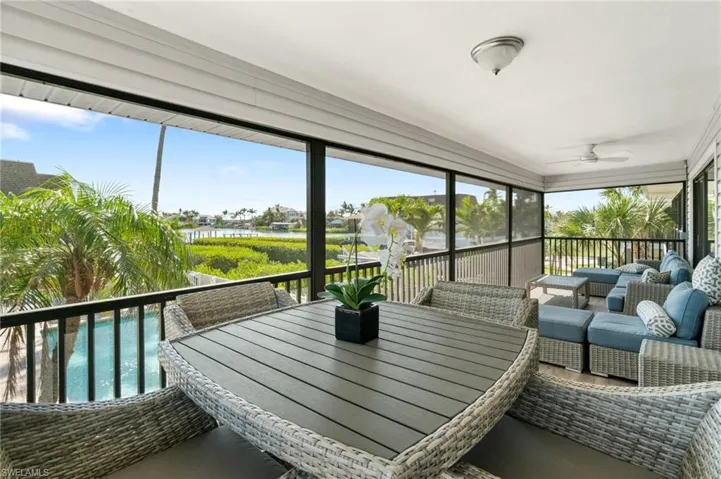 Sunroom with a ceiling fan, a water view, an outdoor living space, and outdoor dining area