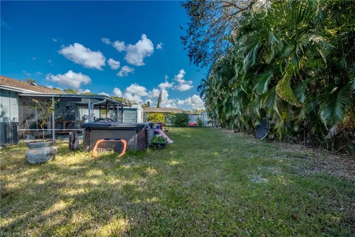Fenced backyard with a hot tub
