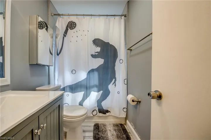 Bathroom featuring vanity and shower / bathtub combination with curtain