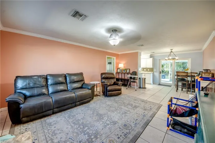 Living room featuring ornamental molding and light tile patterned floors