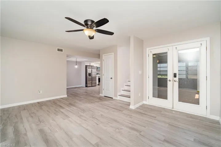 Spare room with french doors, light wood-style flooring, and ceiling fan