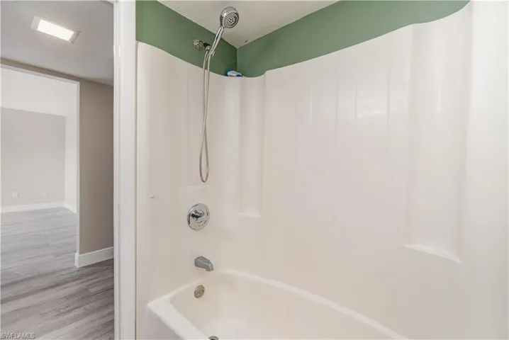 Full bathroom with bathtub / shower combination and wood finished floors