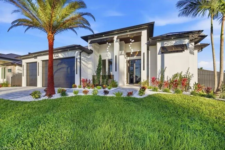 View of front facade with stucco siding, driveway, and a garage