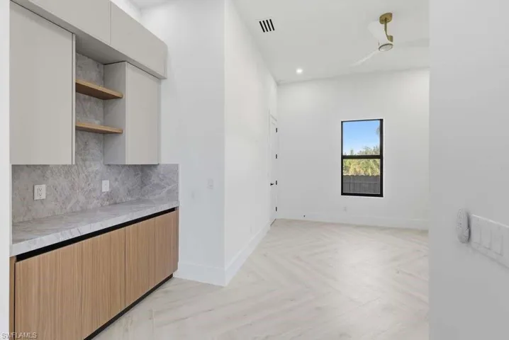 Dual tone kitchen with open shelves, light countertops, parquet floors, modern cabinets, and backsplash