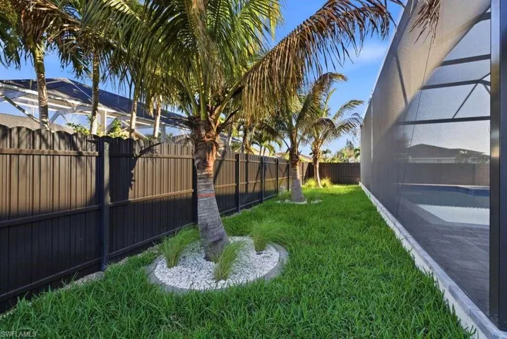 Fenced backyard featuring glass enclosure and a sunroom