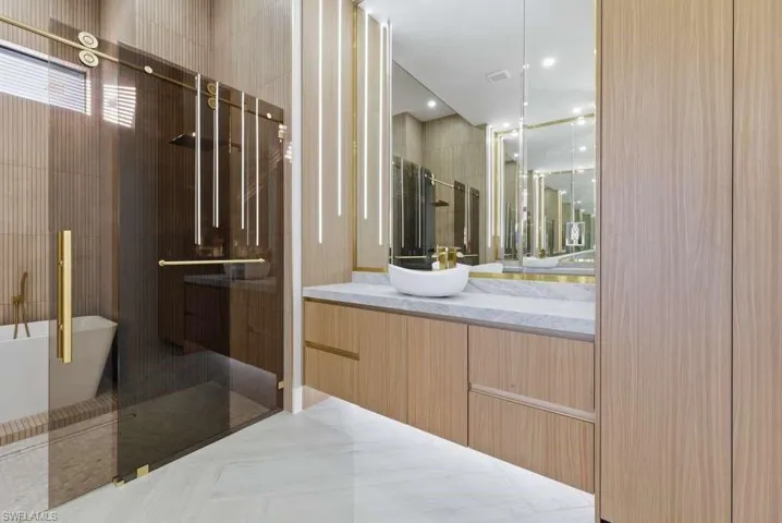Bathroom featuring vanity, a stall shower, and a soaking tub