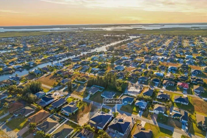Aerial view of property and surrounding area with a large body of water and nearby suburban area