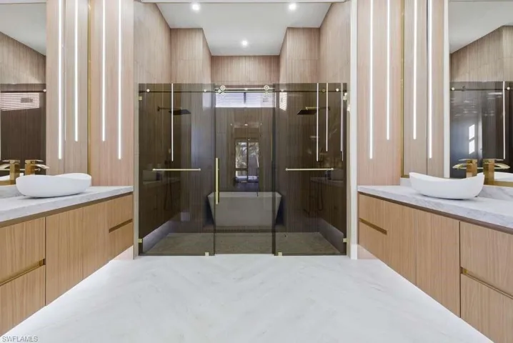 Bathroom with two vanities and a stall shower