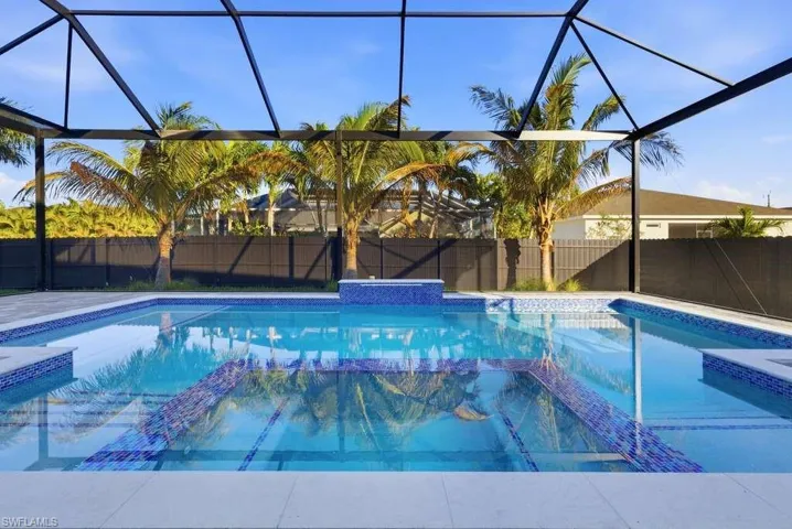 Combined pool / hot tub with glass enclosure, a sunroom, and a fenced backyard