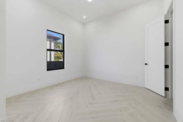 Empty room with recessed lighting and parquet floors