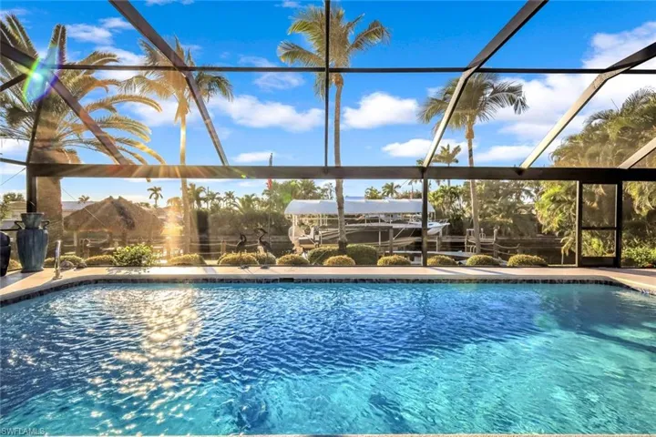 Swimming pool featuring glass enclosure and a sunroom