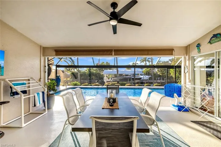 Swimming pool featuring a sunroom, a patio, a lanai, and outdoor dining area
