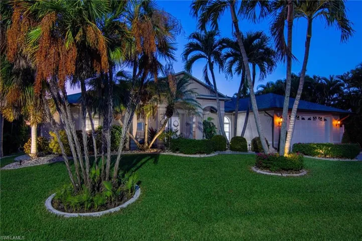 View of front of home featuring a front lawn, a garage, and stucco siding