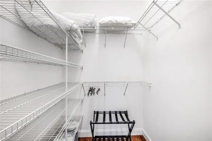 Spacious closet with dark wood-style floors
