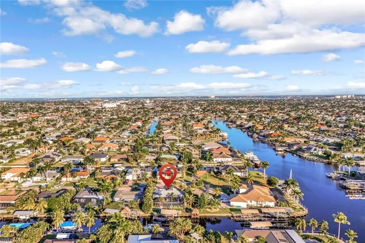 Aerial view of property and surrounding area with nearby suburban area and a nearby body of water