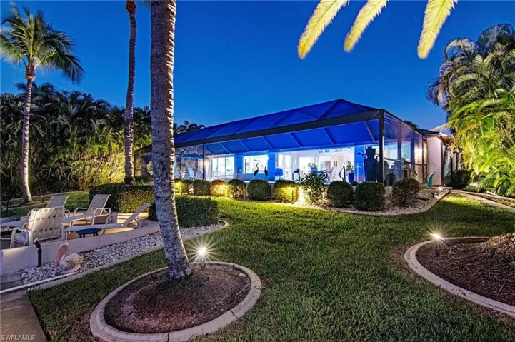 Yard at twilight with a lanai, a lawn, and a patio area