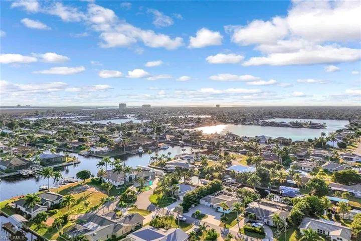 Aerial view of property and surrounding area featuring nearby suburban area and a large body of water
