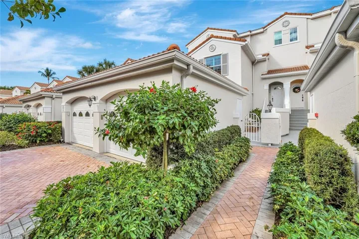 View of front of house featuring stucco siding, an attached garage, decorative driveway, a gate, and a tile roof