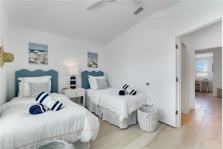 Bedroom with wood finished floors, vaulted ceiling, and ceiling fan