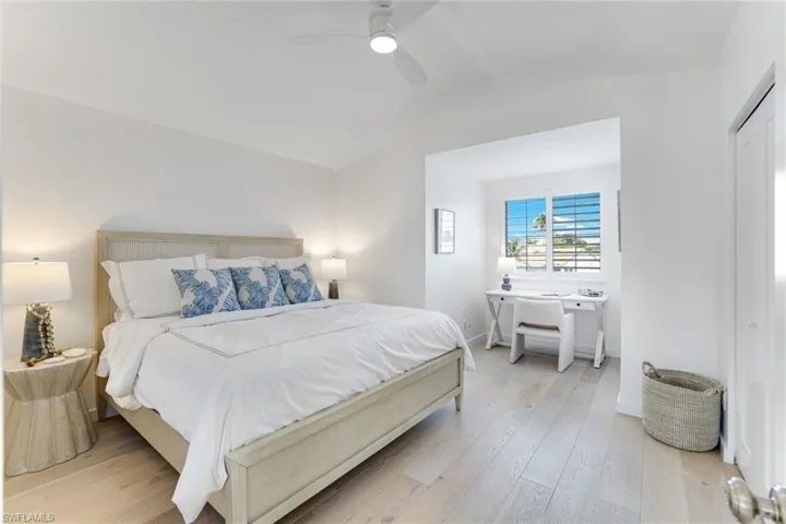 Bedroom with light wood-type flooring, lofted ceiling, and ceiling fan