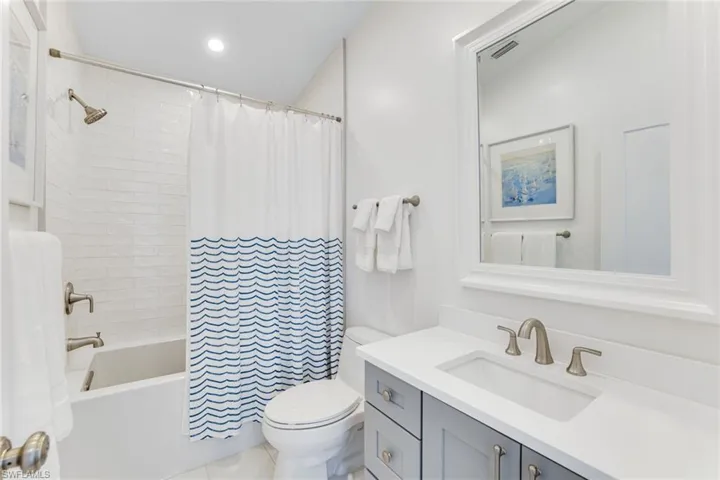 Full bathroom featuring shower / bath combo with shower curtain, vanity, recessed lighting, and light tile patterned floors