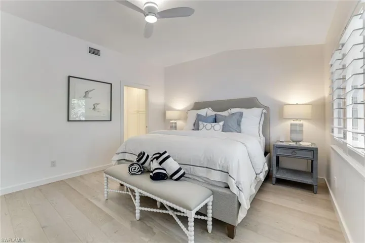 Bedroom with light wood-type flooring, lofted ceiling, and ceiling fan