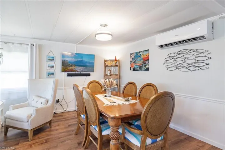 Dining room featuring a wall mounted AC and wood finished floors