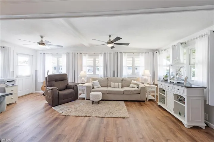 Living area featuring a wealth of natural light, light wood-type flooring, and a ceiling fan