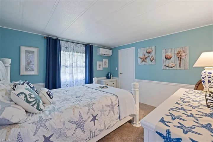 Bedroom with carpet and a wall mounted air conditioner