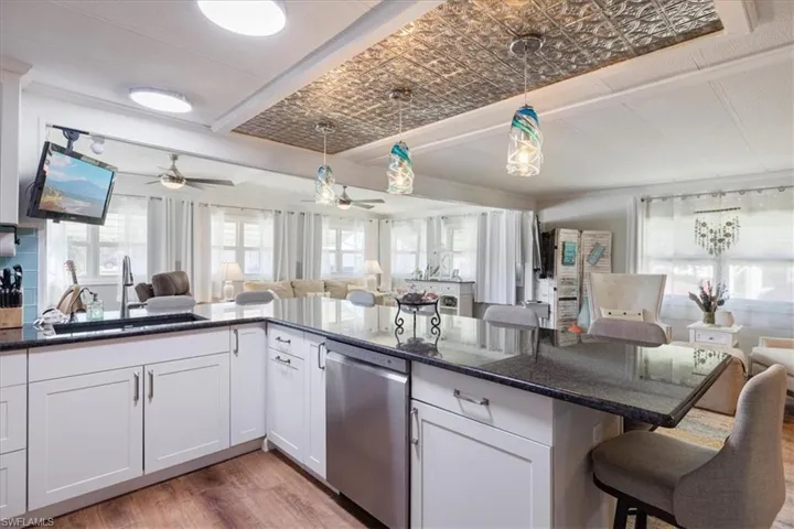 Kitchen featuring open floor plan, a sink, an ornate ceiling, and stainless steel dishwasher