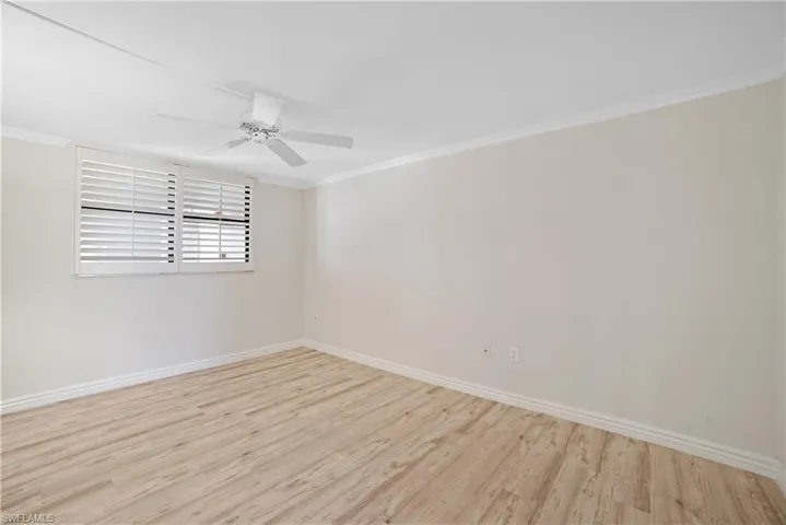 Empty room with ornamental molding, light hardwood / wood-style flooring, and ceiling fan