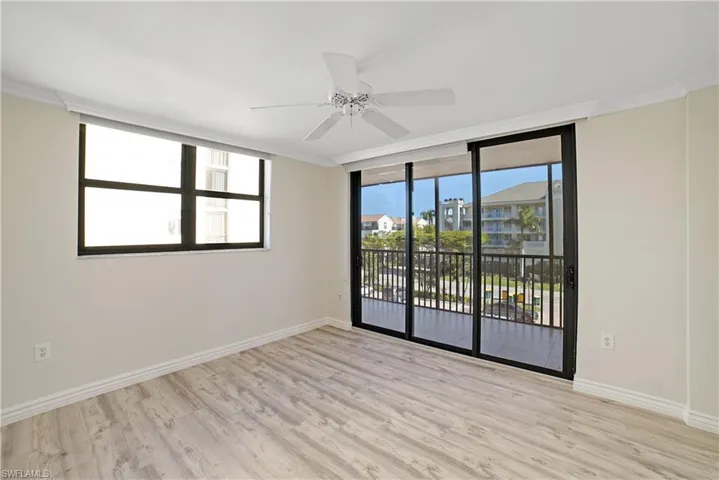 Spare room featuring ceiling fan, light wood-type flooring, and ornamental molding
