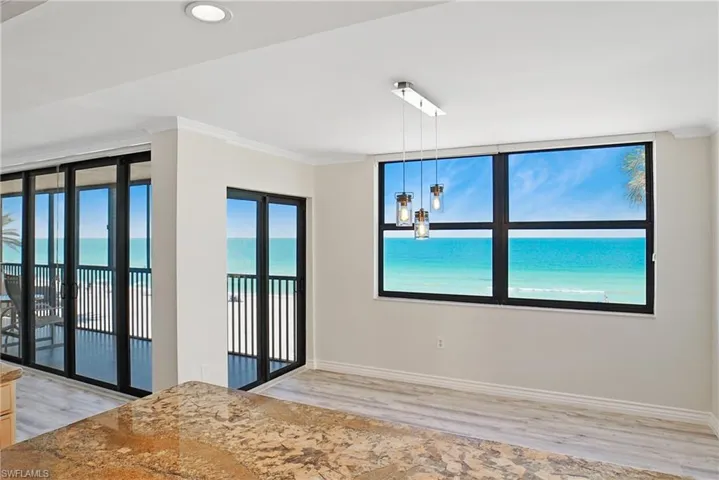 Spare room featuring ornamental molding, light wood-type flooring, and a water view