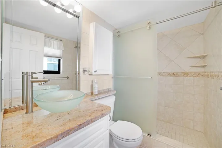 Bathroom with vanity, toilet, and an enclosed shower