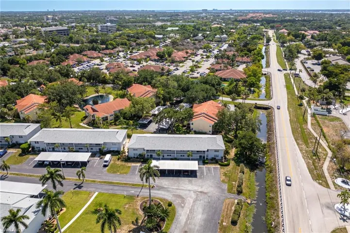 Aerial perspective showcasing multiple residential buildings with light-colored exteriors and grey roofs
