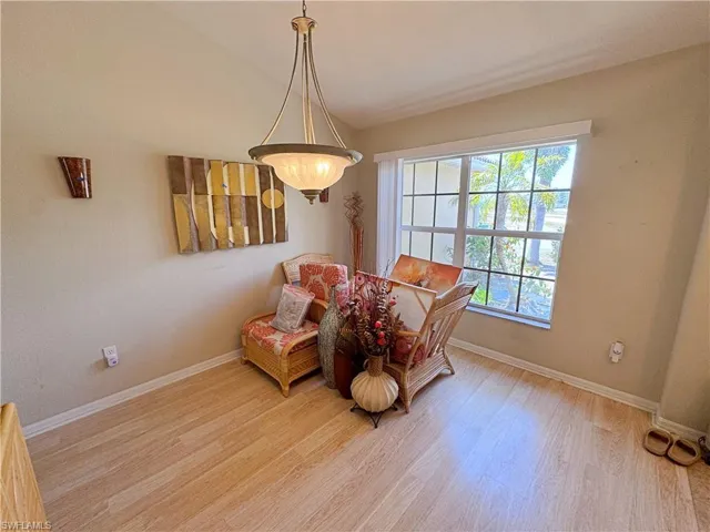 Sitting room with wood finished floors, baseboards, and lofted ceiling