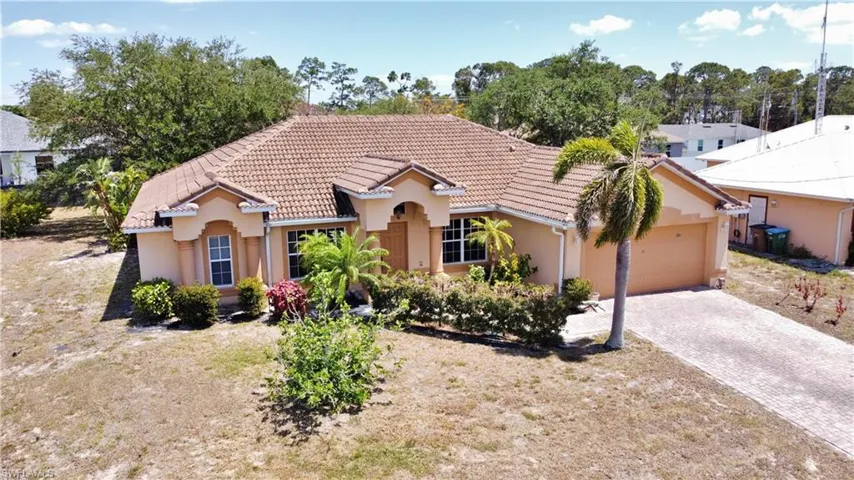 Mediterranean / spanish home with a tiled roof, an attached garage, decorative driveway, and stucco siding