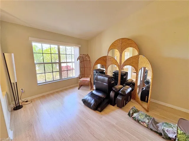 Living area featuring wood finished floors, baseboards, and vaulted ceiling