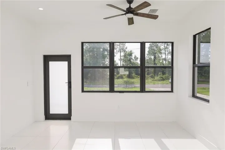 Bright interior space featuring white walls and light-toned tile flooring