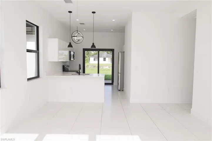 Open-concept living space with large format white tile flooring