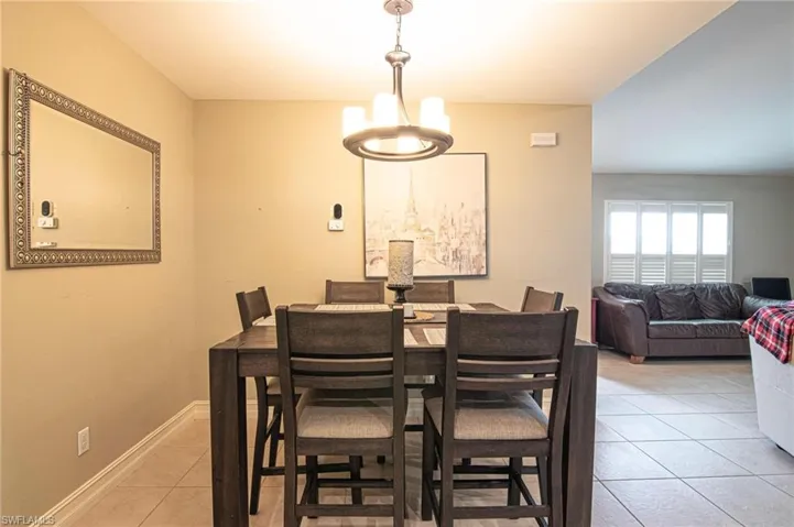 Dining area featuring light tile patterned flooring and a chandelier