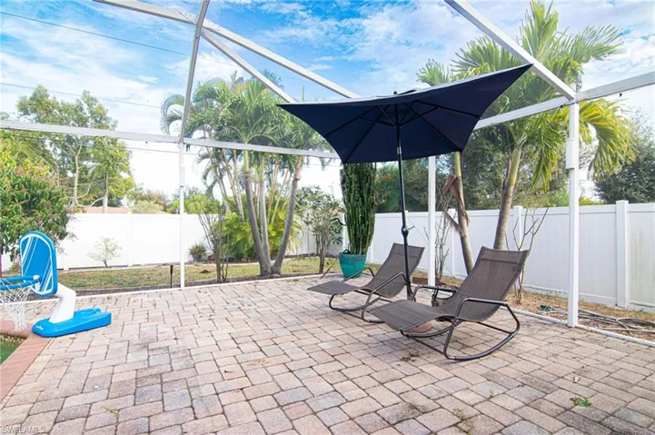 Fenced backyard featuring a patio and glass enclosure