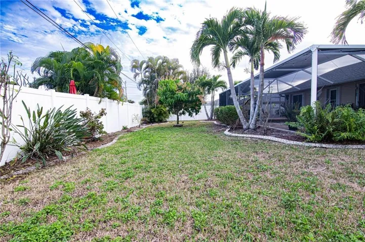 Fenced backyard with a lanai and a sunroom