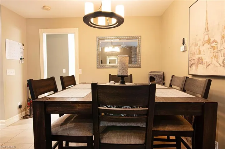 Dining area featuring light tile patterned flooring and a chandelier