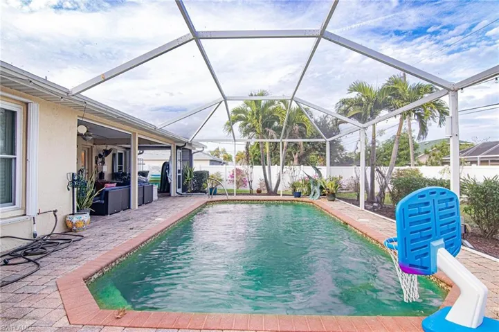 View of swimming pool with glass enclosure, a fenced backyard, a sunroom, and a patio