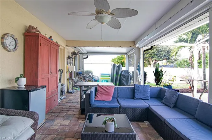 View of patio with ceiling fan, an outdoor living space, and a sunroom
