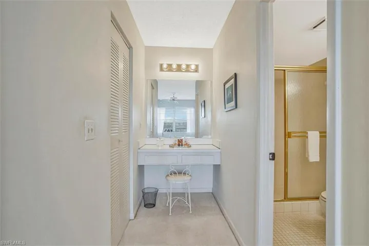 Corridor featuring baseboards and light colored carpet