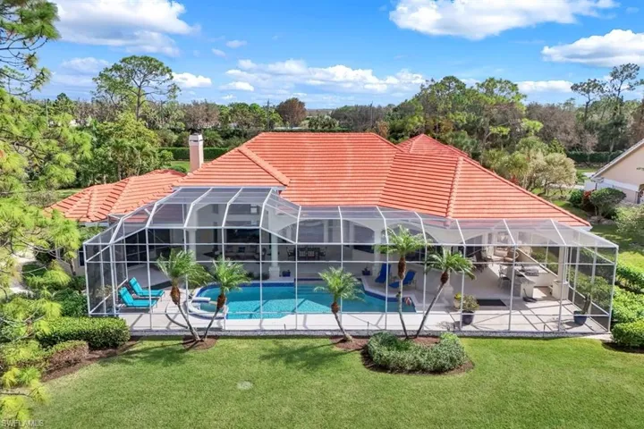 View of pool with a yard, a patio area, and glass enclosure