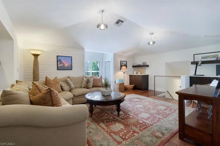 Living room with lofted ceiling and hardwood / wood-style floors